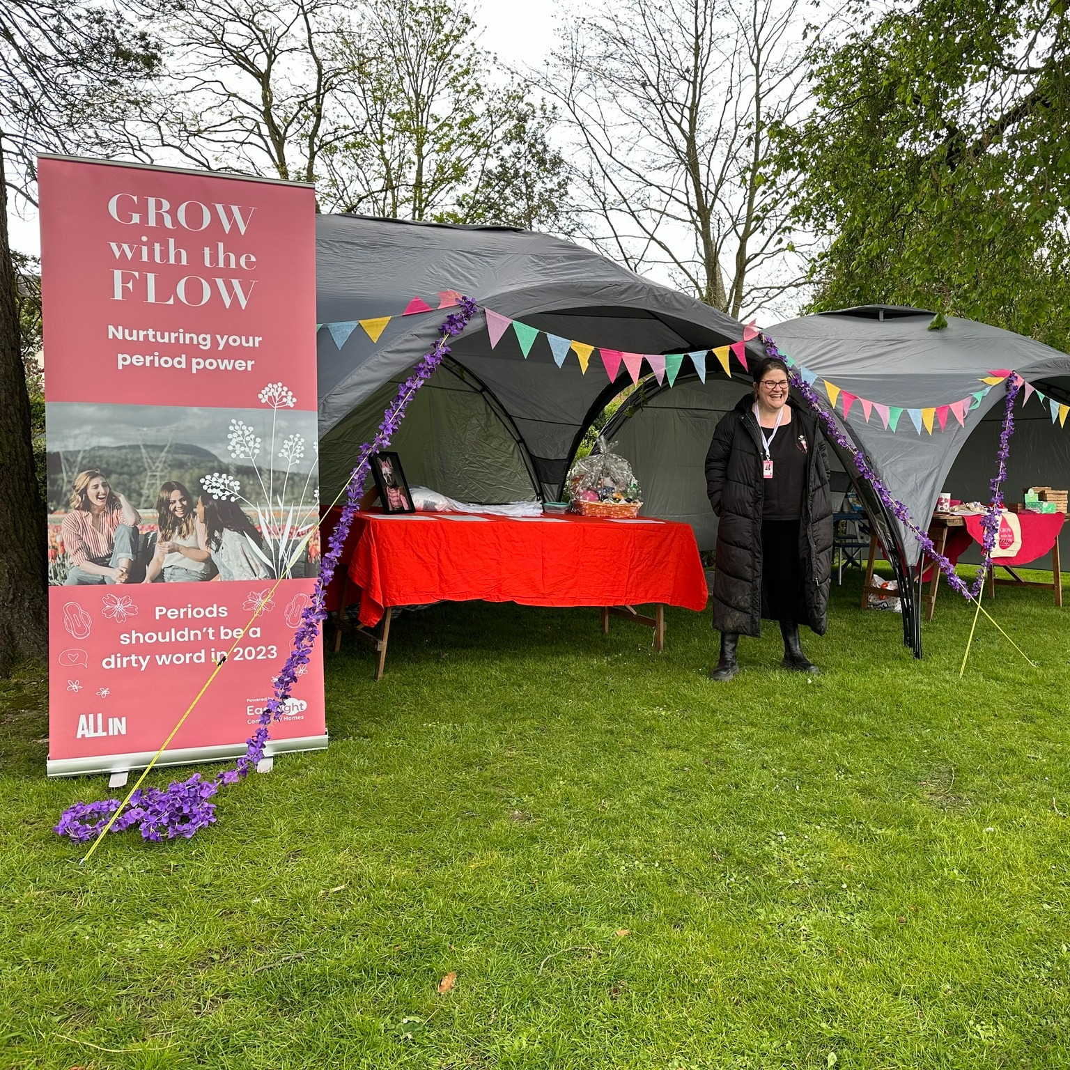 The image shows a tent with a female standing in front of it looking at the camera. There is also a banner stating 'grow with the flow'.