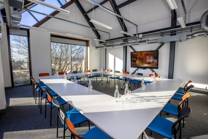 A meeting room with chairs around desks